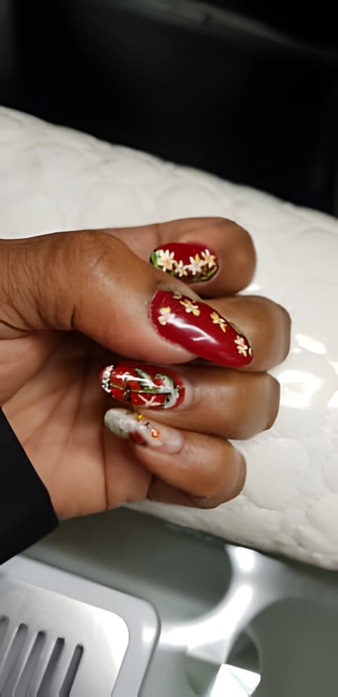 Rode nagels met kleine witte bloemen en steentjes